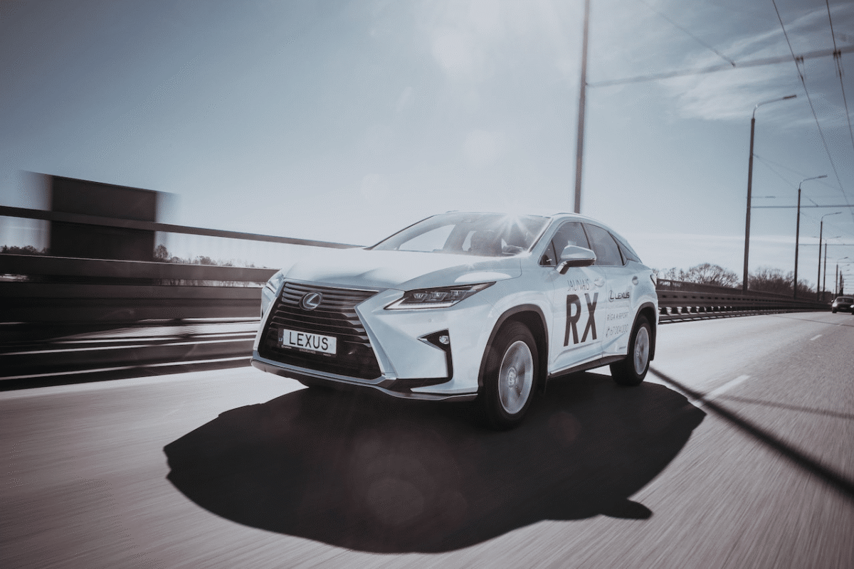 Lexus LBX sur une route moderne entourée de verdure