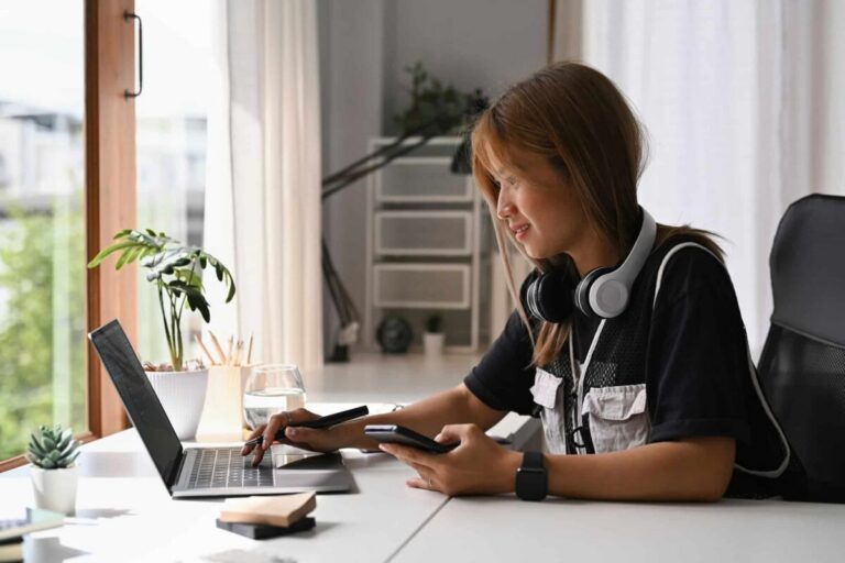 Jeune femme souriante utilisant son téléphone pour apprendre à conduire