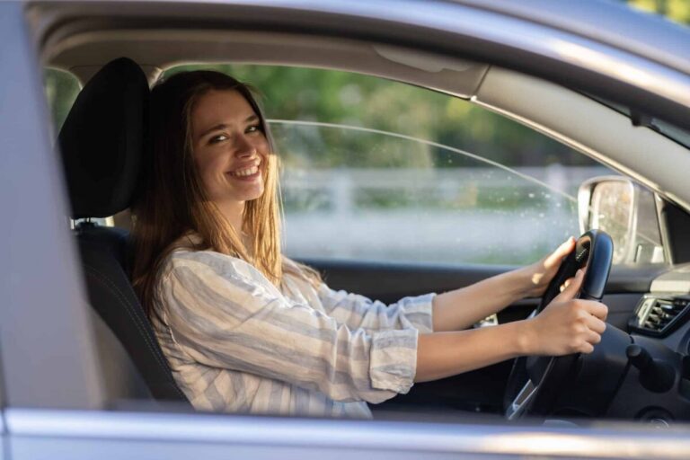 jeune fille assise au volant d'une voiture sans permis
